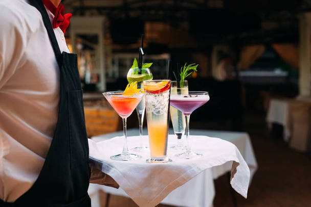 The waiter serves cocktails on a tray - Zdjęcie, obraz