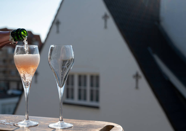 Rózsa pezsgő pezsgő pezsgő öntése fuvolás pohárban Franciaország szabadtéri teraszán napsütéses napokon - Fotó, kép