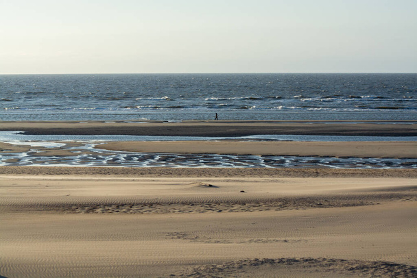 Plage de sable jaune dans la petite ville belge De Haan ou Le Coq sur mer, destination de vacances de luxe, vacances d'été au coucher du soleil - Photo, image