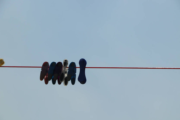 Σιλουέτα με μανταλάκια που κρέμονται από μια γραμμή πλυσίματος το σούρουπο - Φωτογραφία, εικόνα