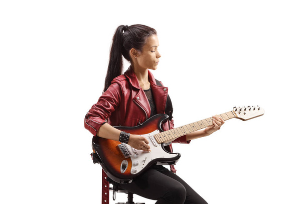 Жінка-музикант сидить і грає на електрогітарі ізольовано на білому тлі
 - Фото, зображення