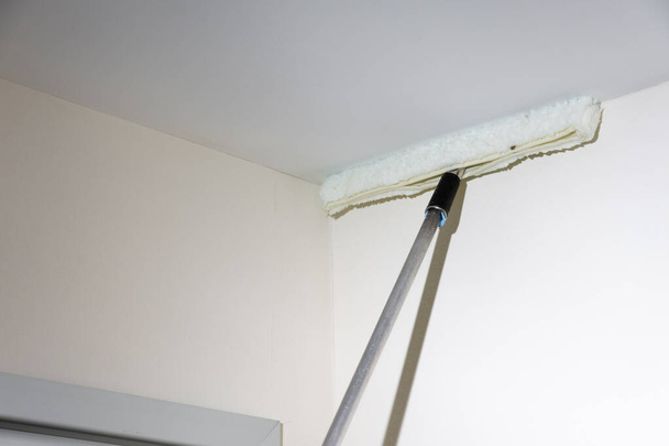 Spazzolone bianco con prolunga per la pulizia dei soffitti di un ospedale - Foto, immagini