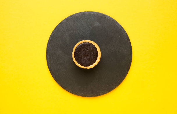 Uma imagem de torta de chocolate servir em placa de ardósia e fundo amarelo. - Foto, Imagem