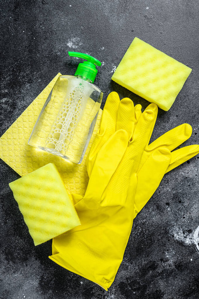 Keuken geel schoonmaken concept, schoonmaken, hygiëne, voorjaar, klusjes, schoonmaak benodigdheden. Zwarte achtergrond. Bovenaanzicht - Foto, afbeelding