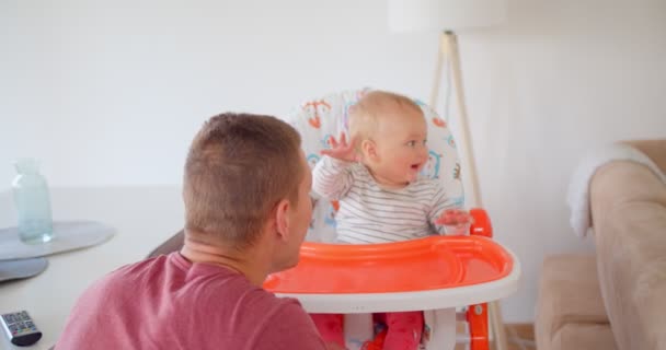Guapo padre está jugando con su bebé niña mientras la hace reír - Imágenes, Vídeo