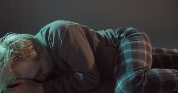 Le jeune garçon est allongé et essaie de ne pas pleurer à propos de la douleur en lui - Séquence, vidéo