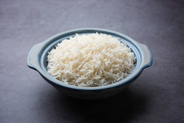 Ароматный длинный басмати, приготовленный простой рис, является индийским основным блюдом, подаваемым в миске. селективный фокус - Фото, изображение