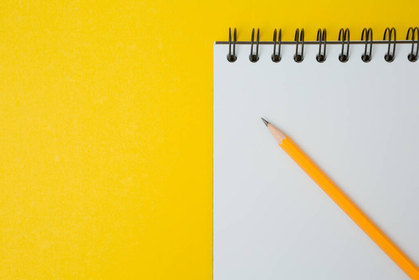 Vista dall'alto di Notebook, matita su sfondo giallo e spazio di copia - Foto, immagini