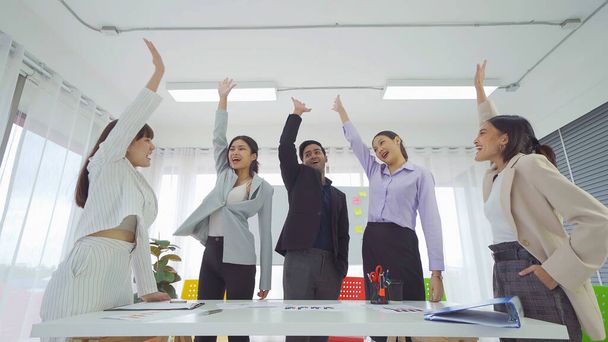 Grupo de empresarios asiáticos exitosos que se apilan las manos para animar al equipo a reunirse, comunicarse, discutir y trabajar con colegas en la oficina. Estilo de vida de las personas.Trabajo en equipo corporativo - Foto, imagen
