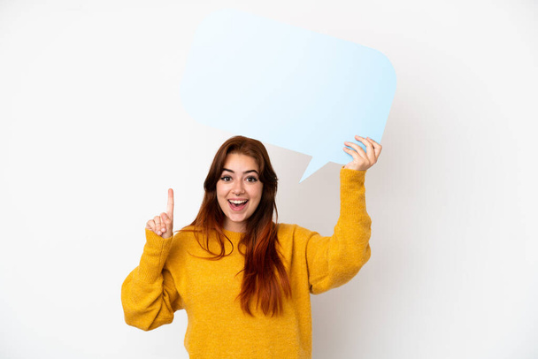 Young redhead woman isolated on white background holding an empty speech bubble with surprised expression - Φωτογραφία, εικόνα