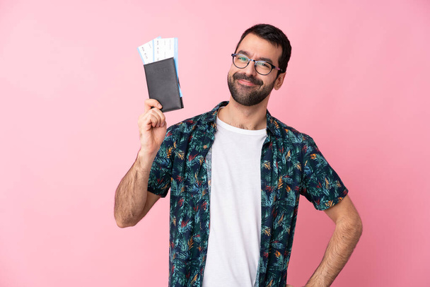 Jeune homme caucasien sur fond isolé heureux en vacances avec passeport et billets d'avion - Photo, image