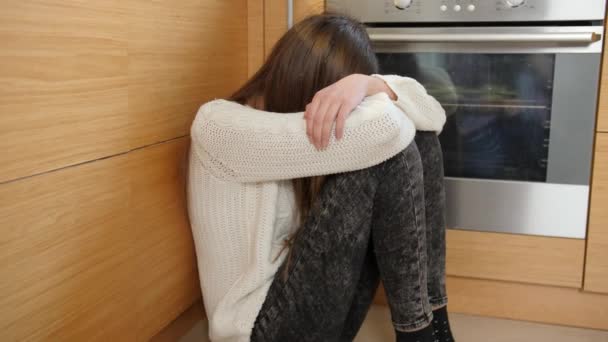 Depressives Teenager-Mädchen, das in der Küche am Boden sitzt und weint. Sich einsam und missverstanden fühlen - Filmmaterial, Video