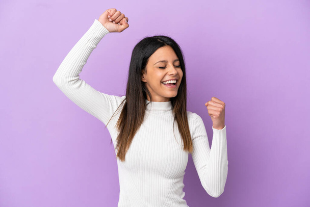 Young caucasian woman isolated on purple background celebrating a victory - Fotografie, Obrázek