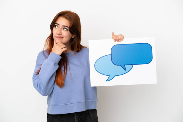 Young redhead woman isolated on white background holding a placard with speech bubble icon and thinking - Photo, Image