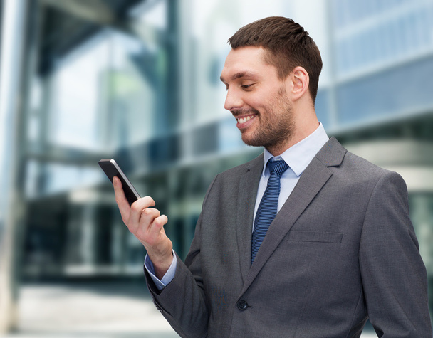 young smiling businessman with smartphone - Photo, image