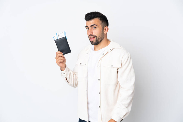 Кавказький чоловік понад ізольованим білим фоном щасливий у відпустці паспортом і квитками на літак. - Фото, зображення