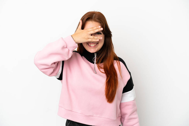 Young redhead woman isolated on white background covering eyes by hands and smiling - Foto, afbeelding