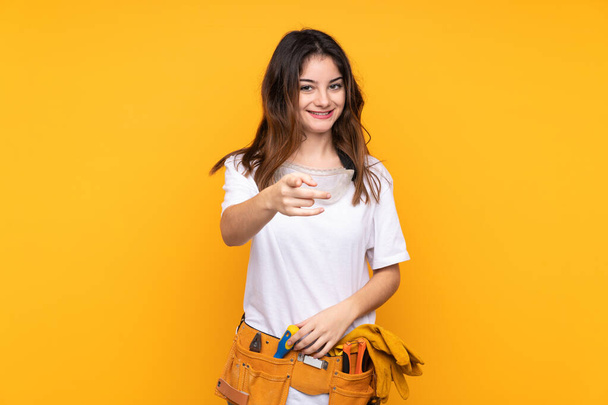 Nuori sähköasentaja nainen yli eristetty keltainen tausta osoittaa sormella sinua - Valokuva, kuva