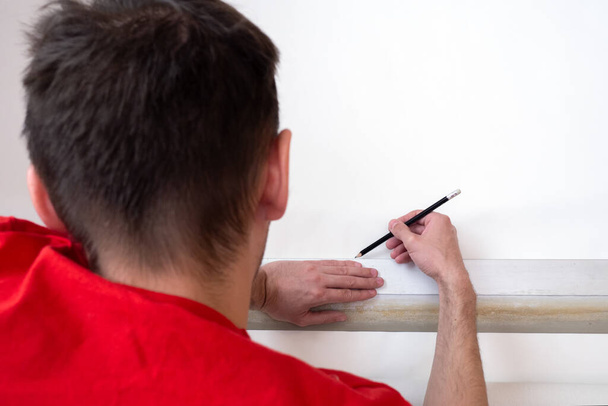 Man repair measures the length of the strip of wallpaper. renovation apartment - Foto, imagen