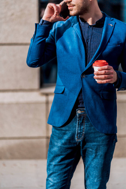 Fashion businessman having phone conversation walking in city center - Foto, afbeelding