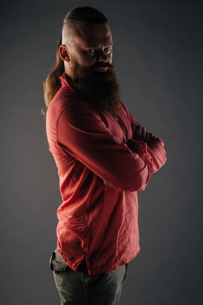 Όμορφη ισχυρή Nordic άνθρωπος με κομψό χτένισμα και γενειάδα σε ένα απομονωμένο φόντο. - Φωτογραφία, εικόνα