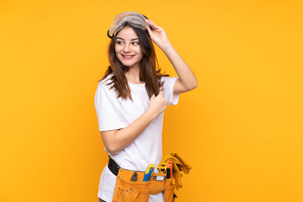 Giovane elettricista donna oltre isolato su sfondo giallo - Foto, immagini