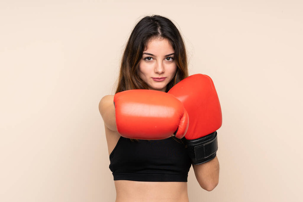 Mladá sportovní žena s boxerskými rukavicemi přes izolované pozadí - Fotografie, Obrázek