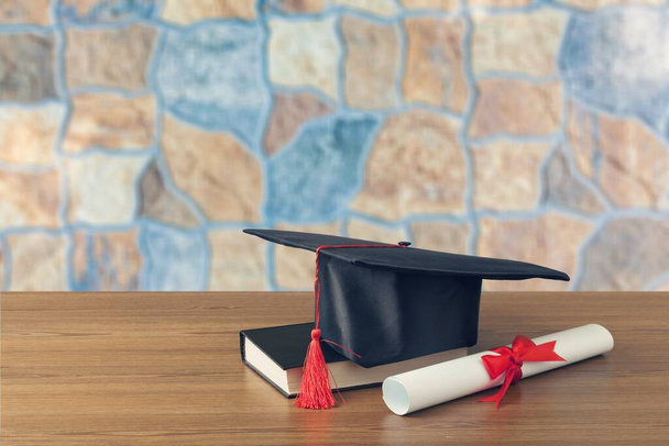graduation cap and diploma on wooden table - Foto, Bild