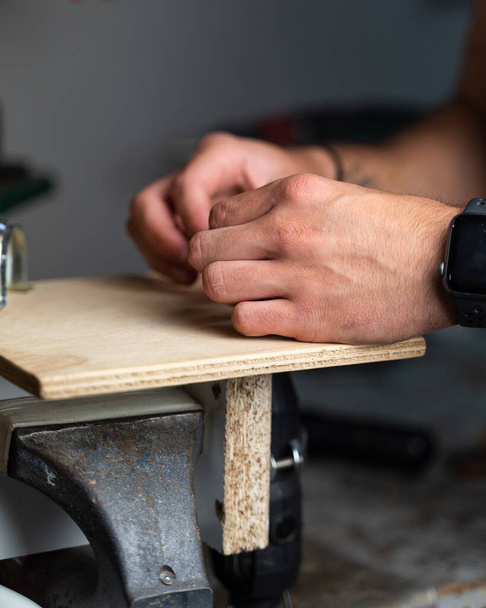 A vertical shot of male hands on a locksmith machine in a workshop - Foto, immagini