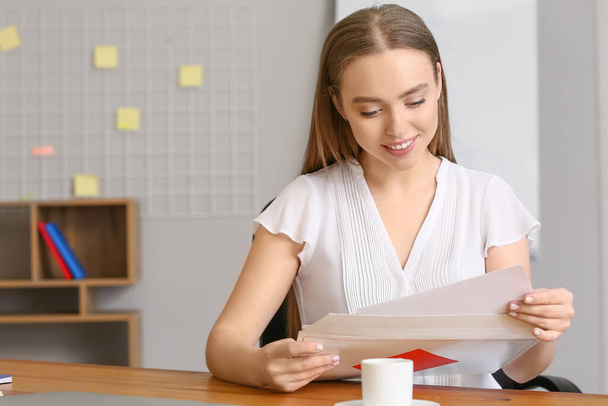 Young woman reading letter in office - Photo, Image
