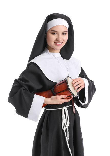 Young nun with drum on white background - Photo, Image