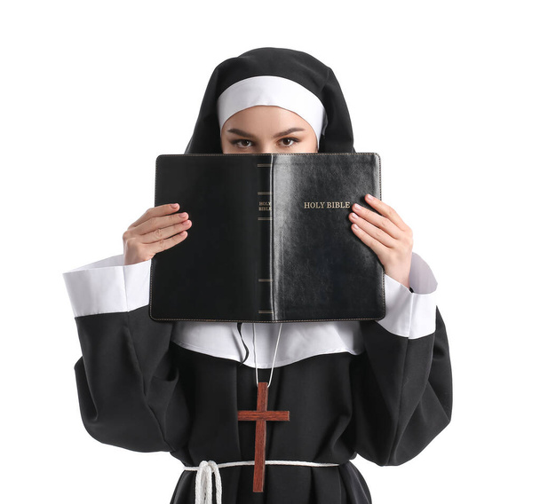 Joven monja con Biblia sobre fondo blanco - Foto, Imagen