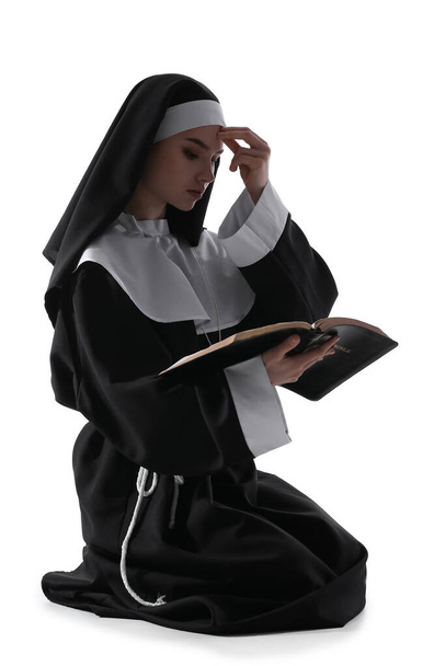 Junge betende Nonne mit Bibel auf weißem Hintergrund - Foto, Bild