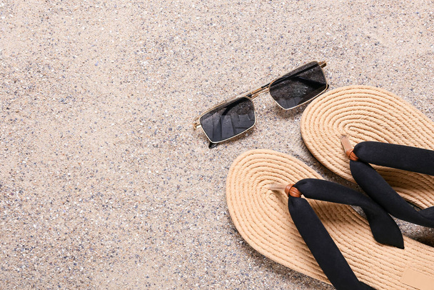 Κομψά γυαλιά ηλίου με σαγιονάρες στην άμμο - Φωτογραφία, εικόνα