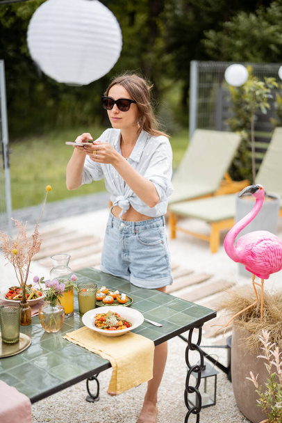 Woman decorating dining table outdoors - Fotó, kép
