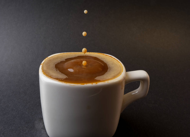 closeup photo of coffee drop in a cup - Fotó, kép