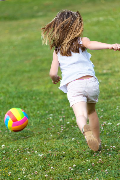 happy little girl playing ball in the park. - Fotó, kép