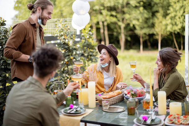 Vrienden dineren in de achtertuin in de zomer - Foto, afbeelding