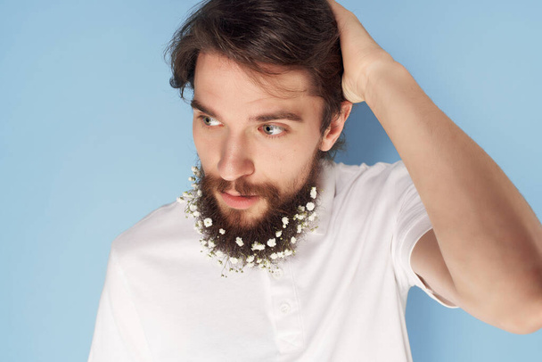 atractivo hombre con flores en barba cuidado del cabello camisa blanca - Foto, Imagen
