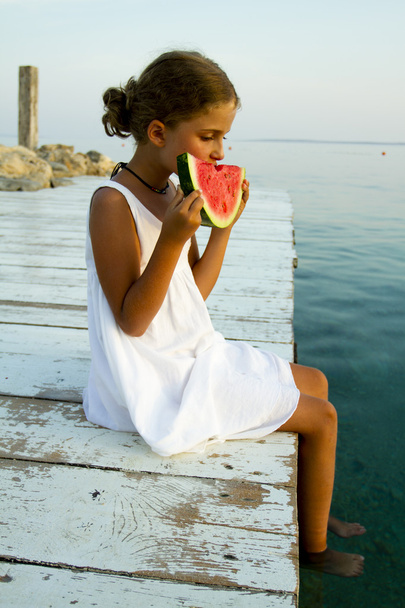 夏の喜びを素敵な女の子、ビーチでの新鮮なスイカを食べる - 写真・画像