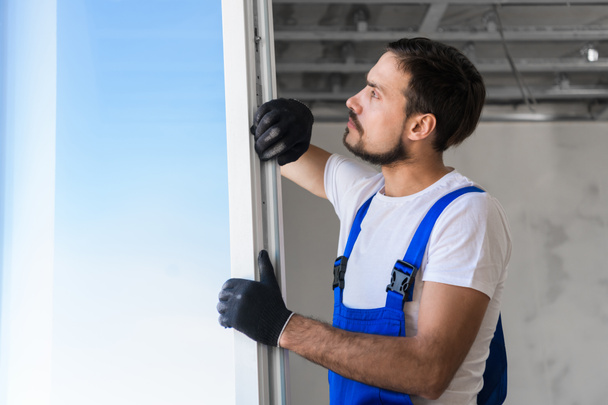 Lavoratore in guanti installa la finestra nell'appartamento - Foto, immagini