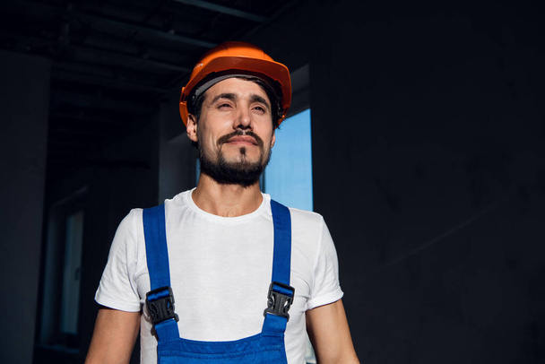 Handsome engineer straightens construction hat on his head - Photo, Image