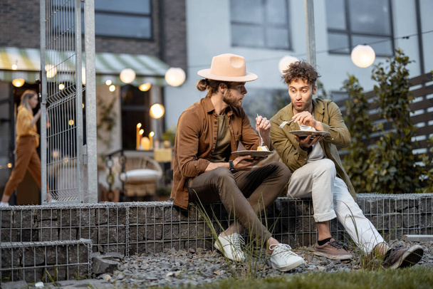 Két férfi barát beszélget a vidéki ház verandáján. - Fotó, kép