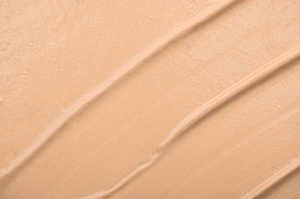 The texture of the foundation close-up, macro. A smear of beige liquid concealer. A sample of a nude cosmetic product for a professional make-up. Basic beauty product for face - Photo, Image