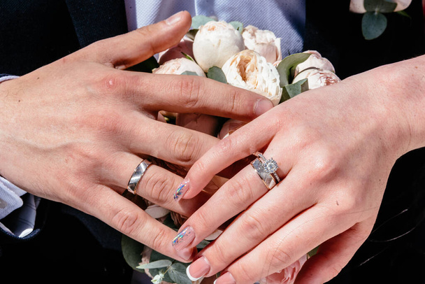 Evlilik yüzükleri takan gençlerin elleri. Düğün günü detayları. Kala çiçekleri. eşler - Fotoğraf, Görsel