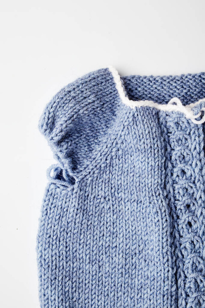 produto de malha azul em agulhas de tricô em um fundo branco - Foto, Imagem