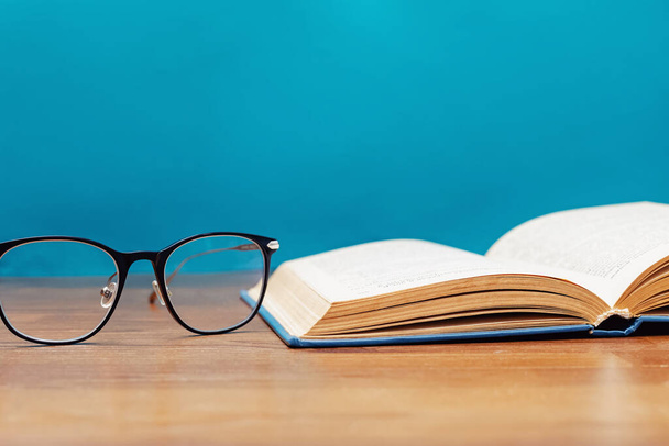 Close-up of reading glasses and opened book - Photo, image