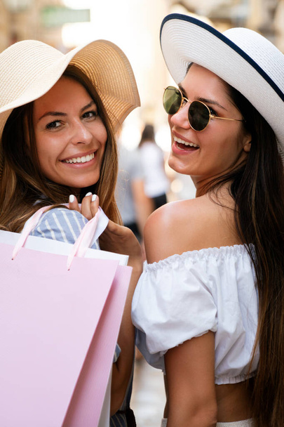 Sale and tourism, happy people concept. Beautiful women with shopping bag in the ctiy having fun - Foto, Imagem
