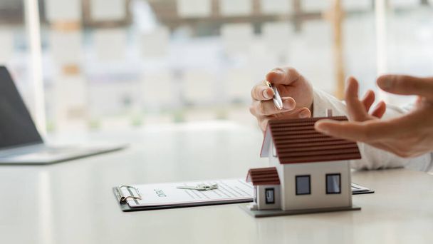 Agente inmobiliario Hable sobre el acuerdo de compra de vivienda y pida al cliente que sea un contrato en el documento para cumplir con la ley. - Foto, imagen