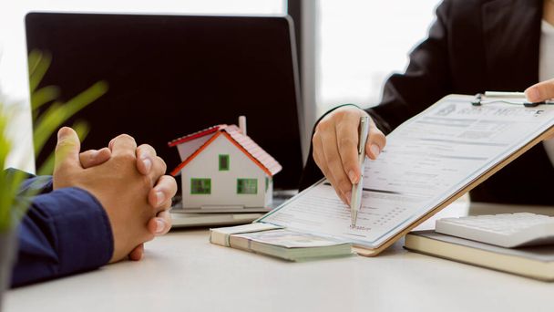 Agent nieruchomości Porozmawiaj o umowie kupna domu i poprosić klienta, aby być kontraktem w dokumencie przestrzegać prawa. - Zdjęcie, obraz